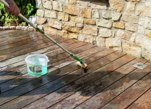 photo de quelqu'un en train d'appliquer le produit dégrisant à l'aide d'un manche téléscopique